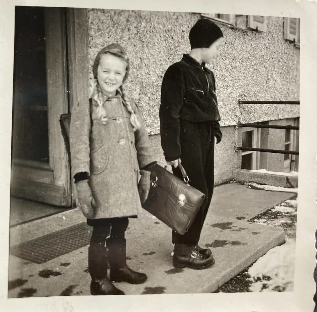 Historische Aufnahme von zwei Kindern mit Schulranzen im Winter