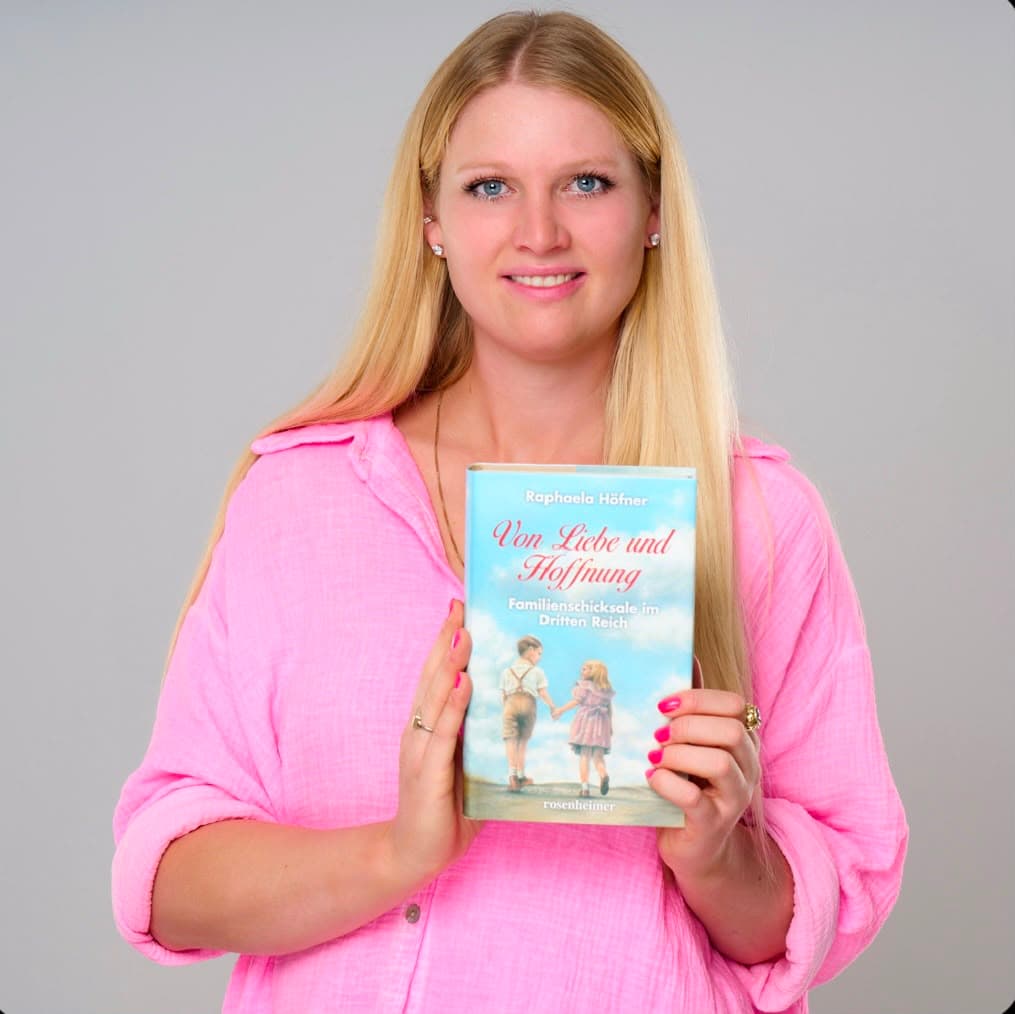 Raphaela Höfner hält den ersten Band „Von Liebe und Hoffnung“ in die Kamera