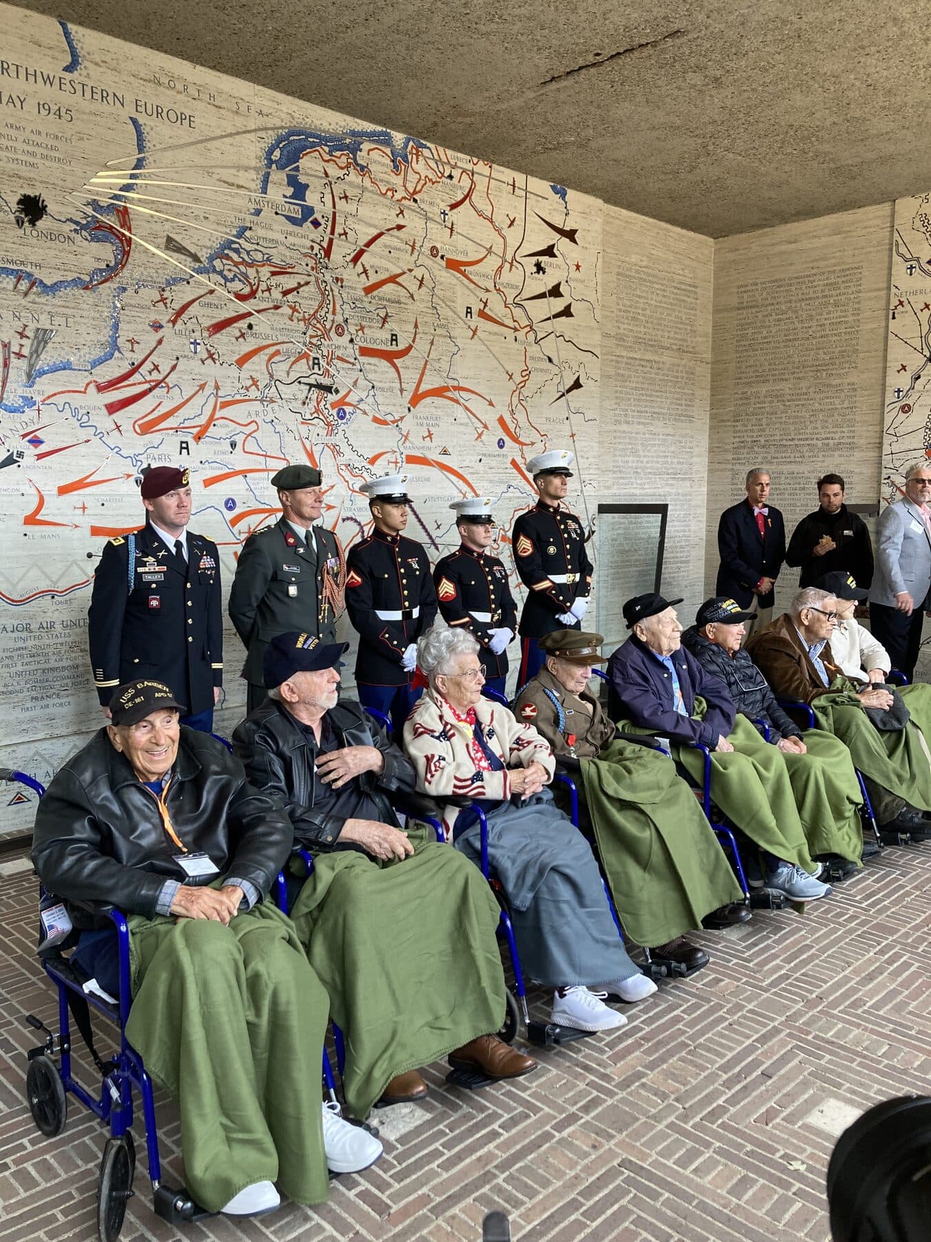 Veteranen des Zweiten Weltkriegs bei einer Gedenkfeier vor einer historischen Wandkarte
