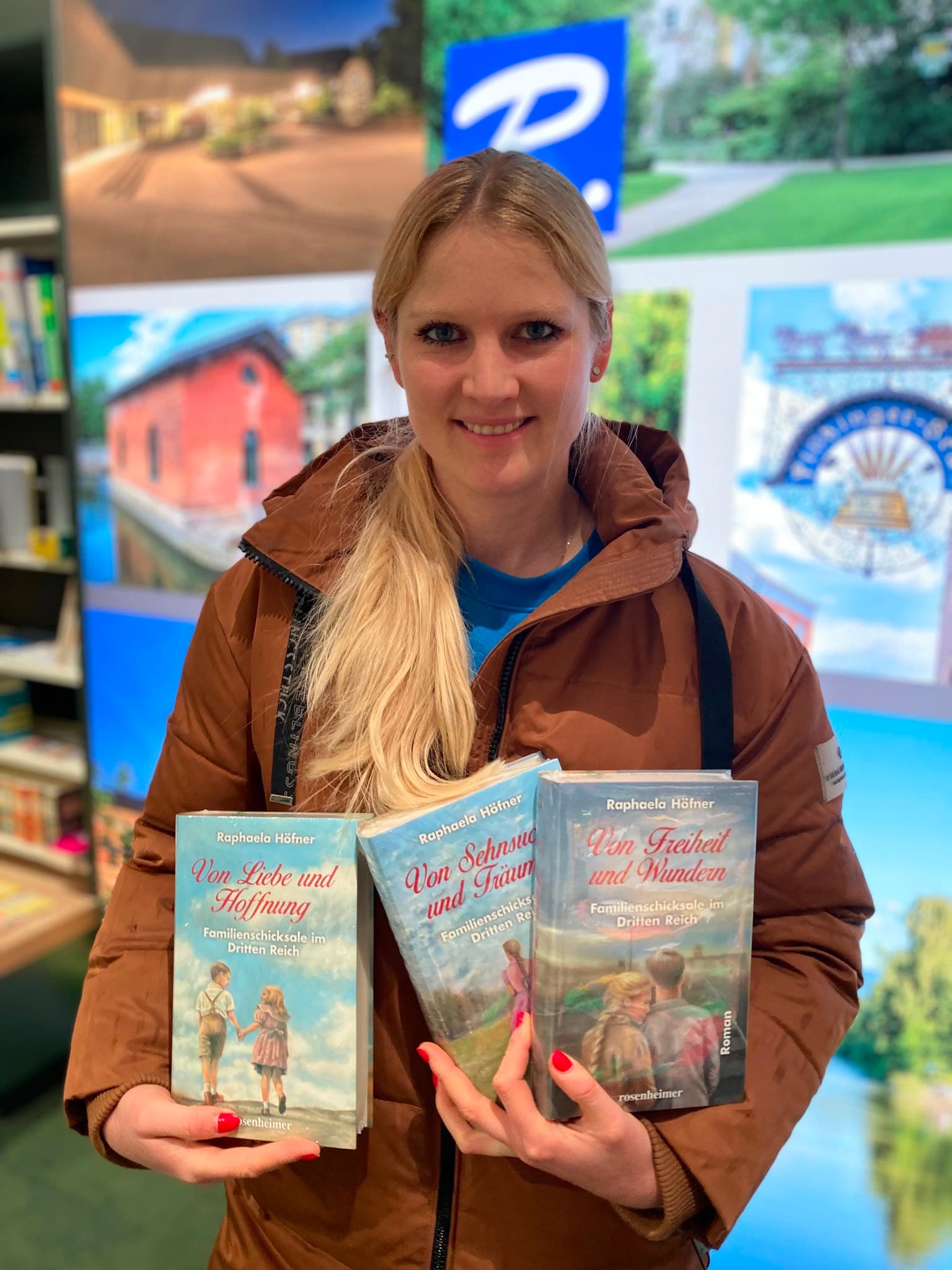 Raphaela Höfner hält alle drei Bände der Trilogie in einer Bibliothek