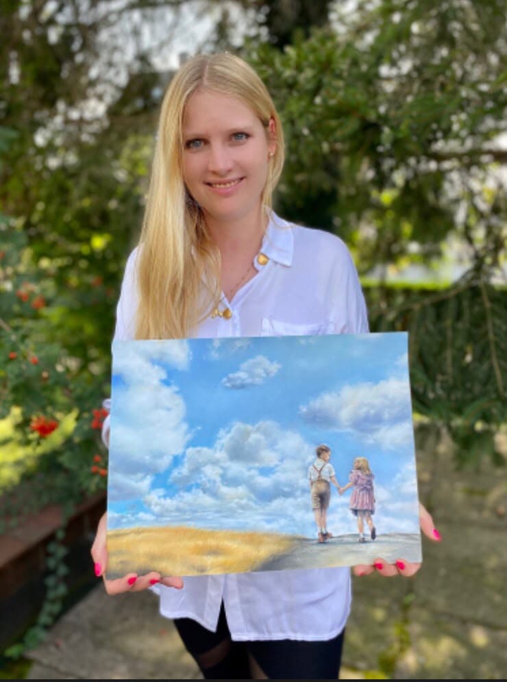 Raphaela Höfner hält das gemalte Originalbild des Covers von „Von Liebe und Hoffnung“