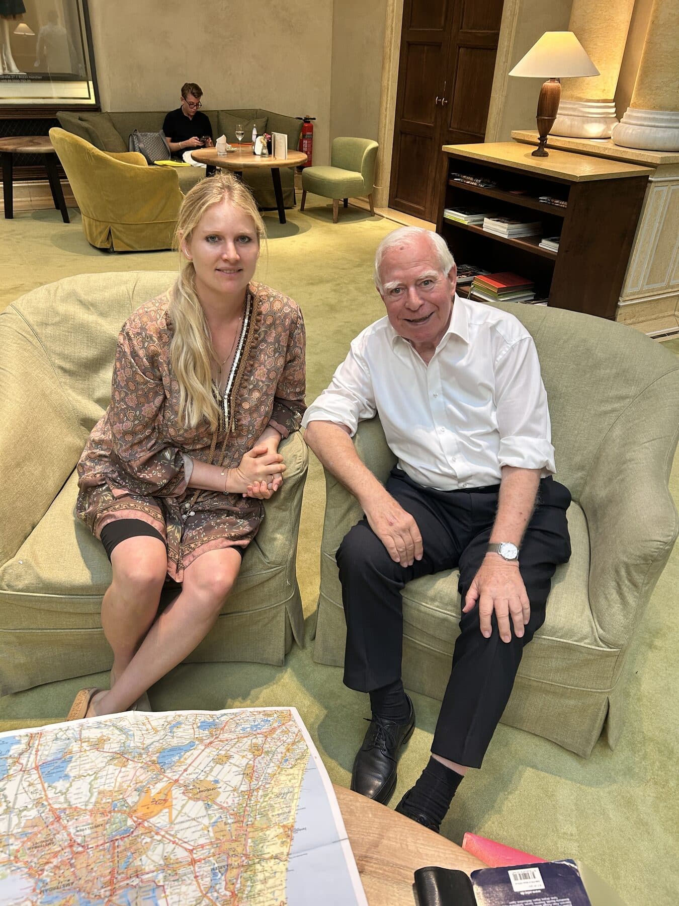 Raphaela Höfner und der Zeitzeuge Ernst Krakenberger sitzen nebeneinander, vor ihnen eine Landkarte