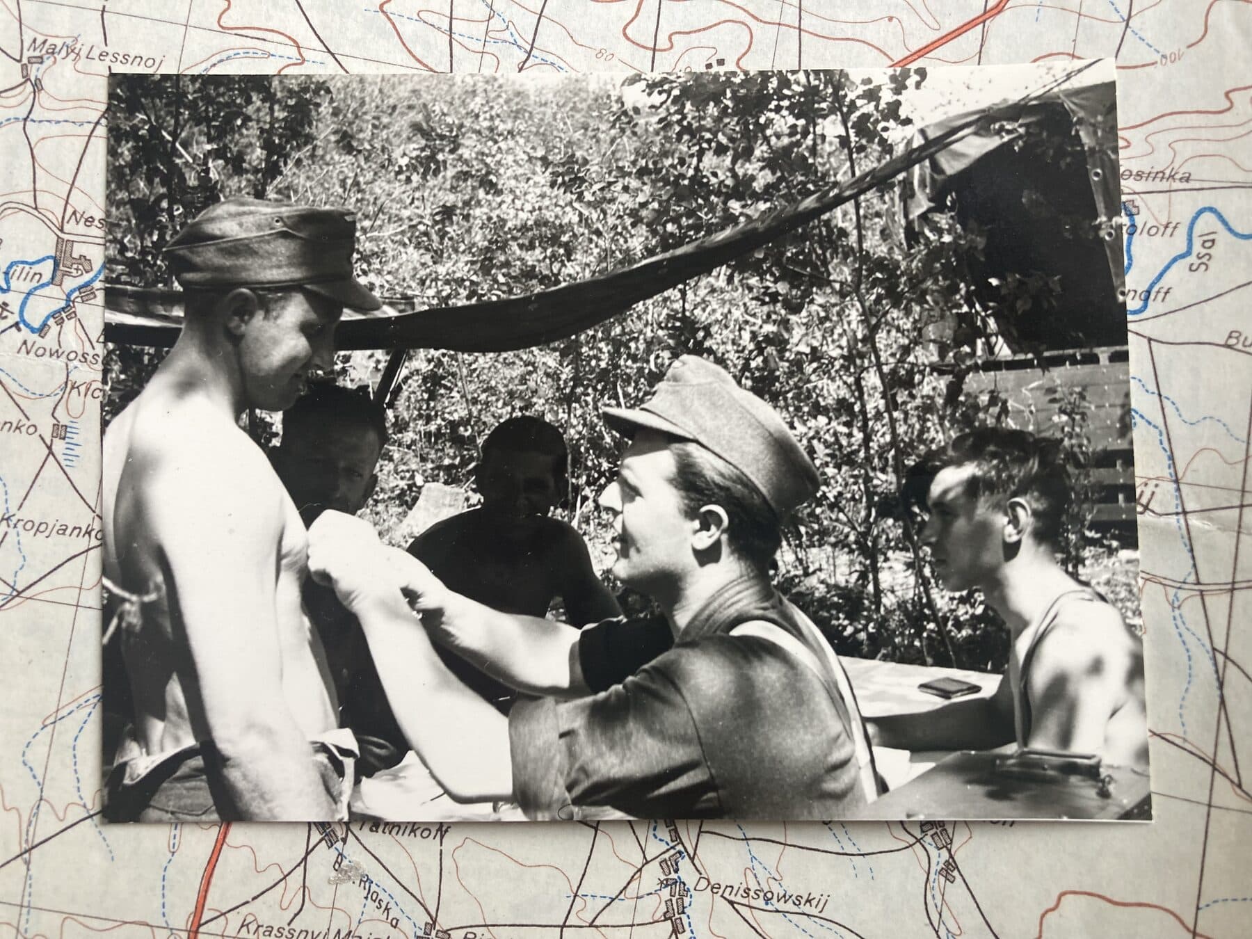 Historische Aufnahme einer Verwundetenversorgung, arrangiert auf einer alten Landkarte