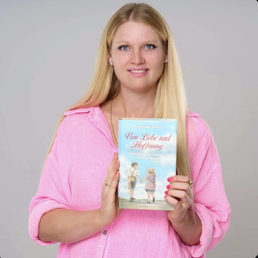 Raphaela Höfner hält den ersten Band „Von Liebe und Hoffnung“ vor sich