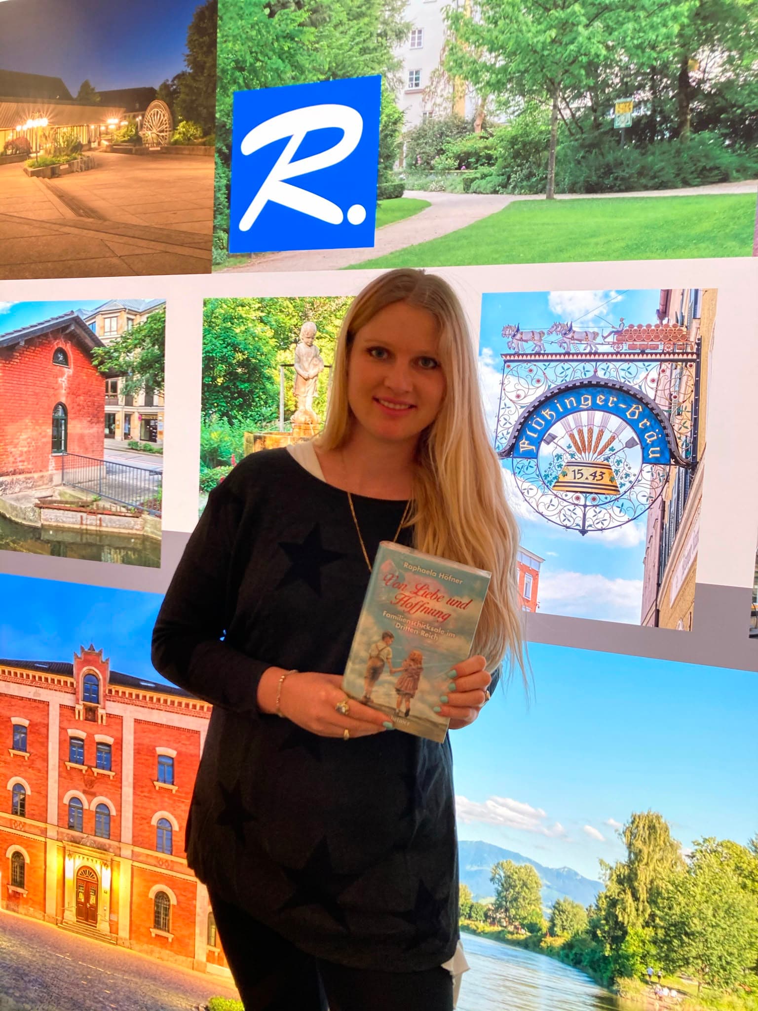 Raphaela Höfner vor einer Bildwand mit Rosenheimer Motiven, den ersten Band in der Hand